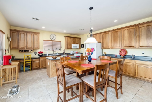 kitchen with light tile patterned floors, dark countertops, recessed lighting, visible vents, and white appliances