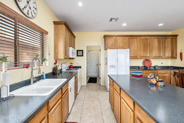 kitchen with white appliances, visible vents, dark countertops, a sink, and recessed lighting