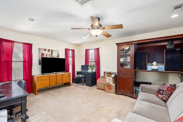 living area with plenty of natural light, visible vents, and light colored carpet