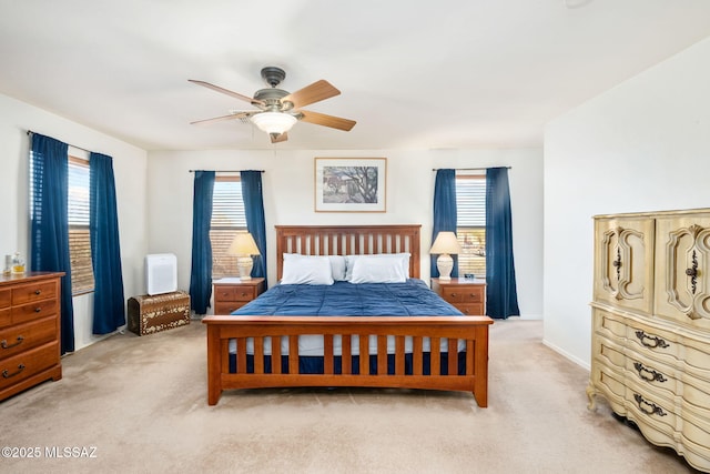 bedroom featuring light carpet, multiple windows, and a ceiling fan