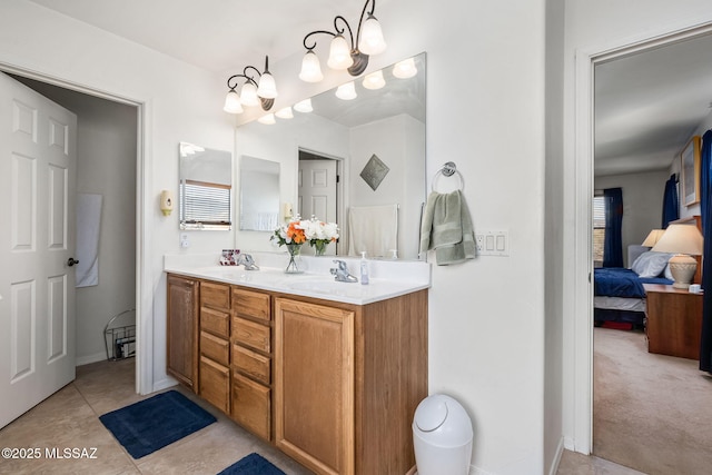 ensuite bathroom with connected bathroom, tile patterned flooring, a sink, and double vanity