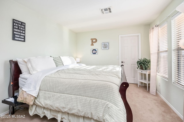 bedroom with light colored carpet, visible vents, and baseboards