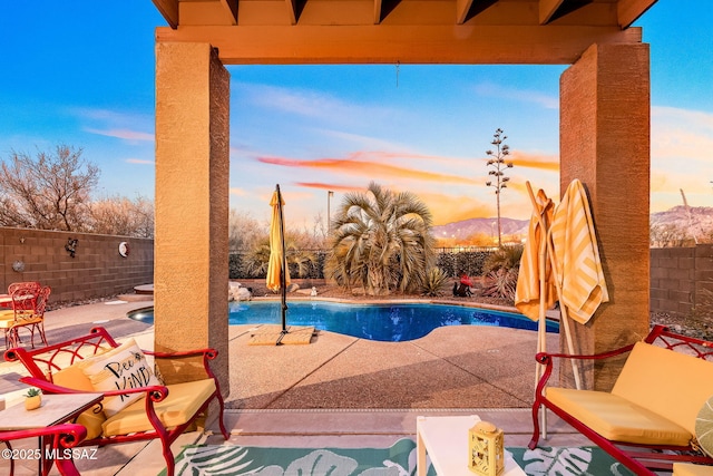 13076 N Desert Olive Dr, Oro Valley, AZ 85755 - pool at dusk featuring a patio, a fenced backyard, and a fenced in pool