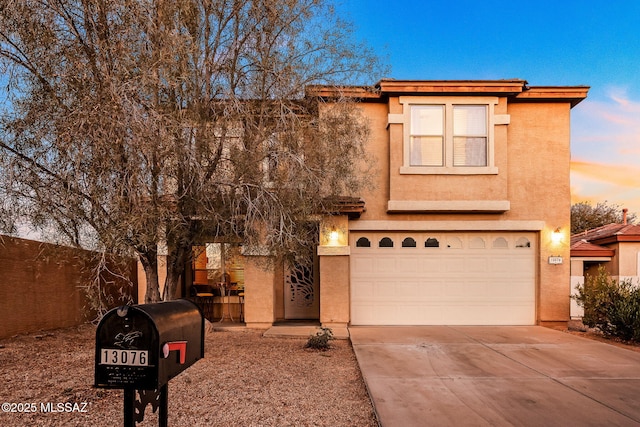 view of front of property featuring concrete driveway, an attached garage, and stucco siding