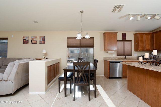 kitchen with light tile patterned floors, visible vents, brown cabinetry, open floor plan, and dishwasher