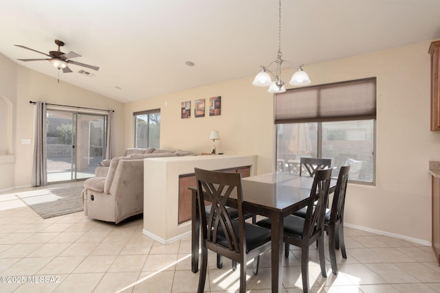 dining space with light tile patterned floors, ceiling fan with notable chandelier, visible vents, baseboards, and vaulted ceiling