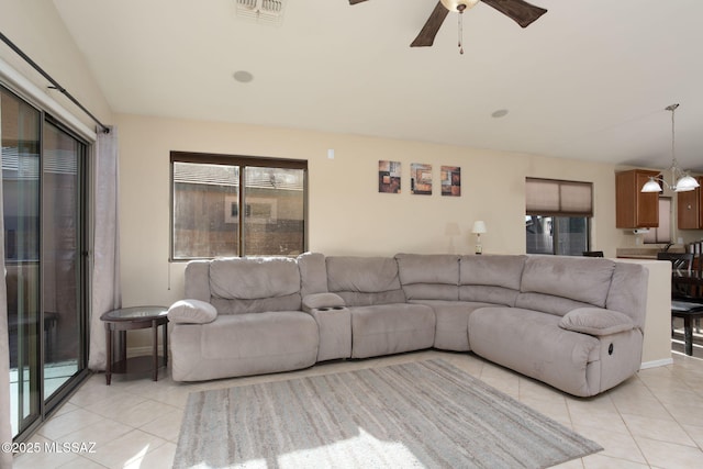 living area with ceiling fan with notable chandelier, visible vents, and light tile patterned floors