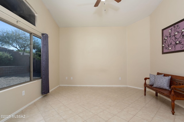 sitting room with ceiling fan, vaulted ceiling, and baseboards