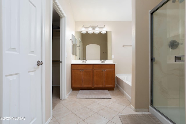 bathroom featuring a garden tub, double vanity, a spacious closet, a shower stall, and tile patterned floors