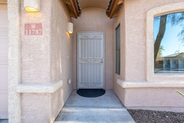 view of exterior entry with stucco siding