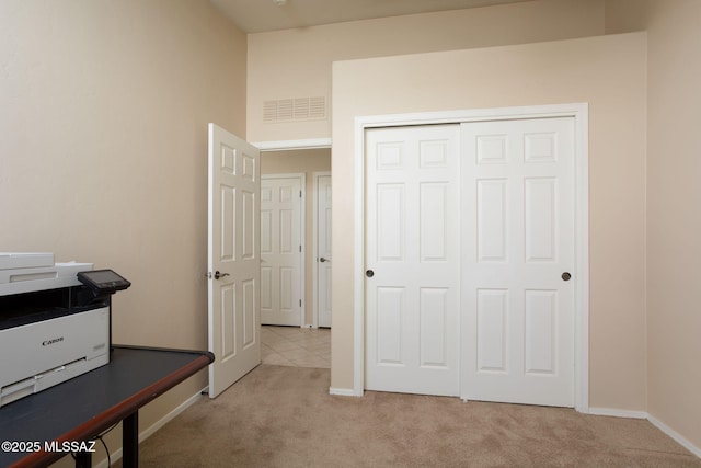 home office featuring light colored carpet, visible vents, and baseboards