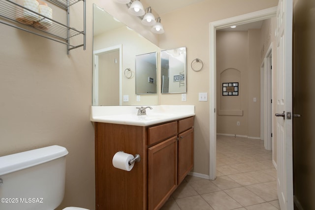 bathroom featuring toilet, baseboards, vanity, and tile patterned floors