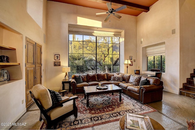 living room with visible vents, baseboards, a towering ceiling, beamed ceiling, and wood finished floors