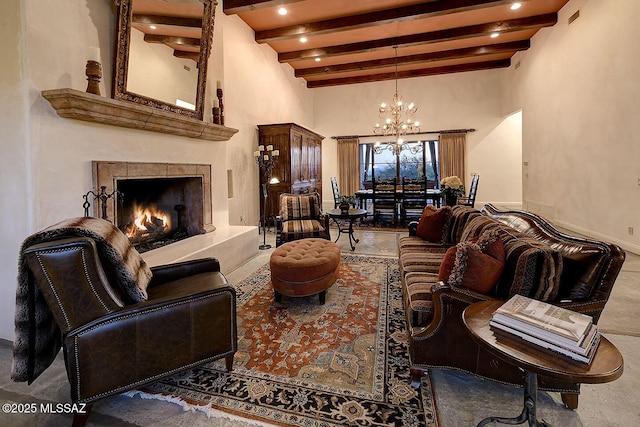 living room featuring an inviting chandelier, a high ceiling, a fireplace, and beam ceiling