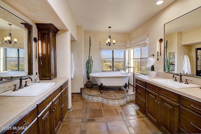 bathroom with a chandelier, two vanities, and a sink