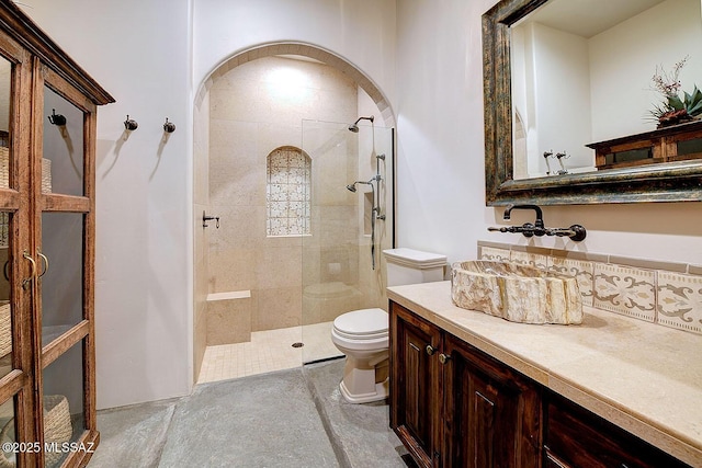 bathroom featuring vanity, toilet, and a walk in shower