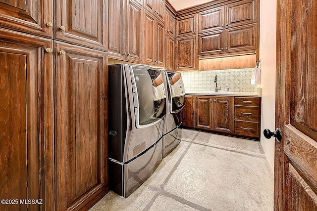 laundry room featuring separate washer and dryer, a sink, and cabinet space