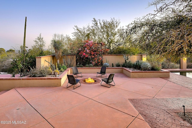 view of patio / terrace with an outdoor fire pit and fence