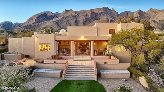 back of house featuring a mountain view and stucco siding