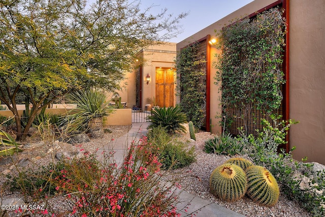 property entrance with fence and stucco siding