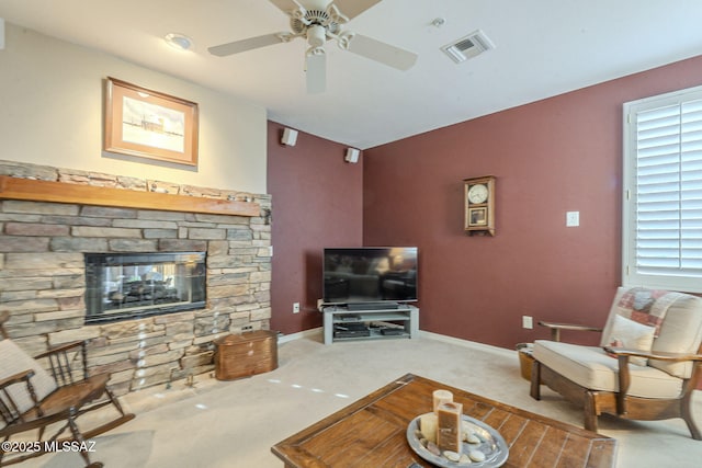 carpeted living room featuring a ceiling fan, a fireplace, visible vents, and baseboards