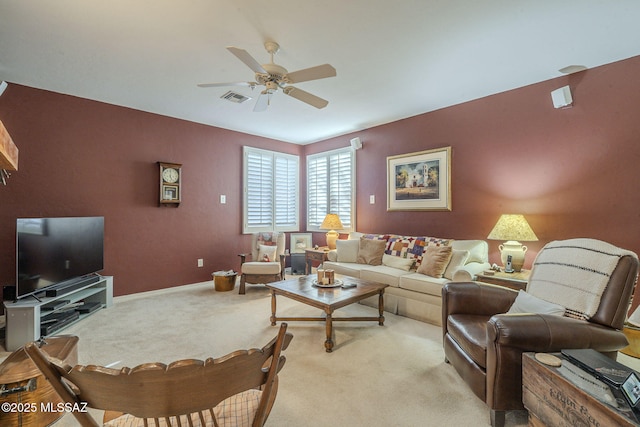 living area with light carpet, visible vents, baseboards, and a ceiling fan