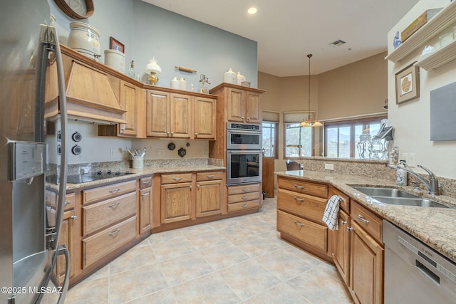 kitchen with visible vents, appliances with stainless steel finishes, brown cabinets, pendant lighting, and a sink