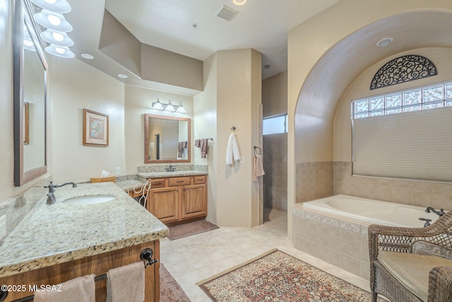 full bathroom featuring a garden tub, visible vents, a sink, and tile patterned floors