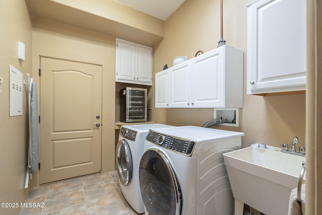 laundry area with cabinet space, separate washer and dryer, a sink, and light tile patterned flooring