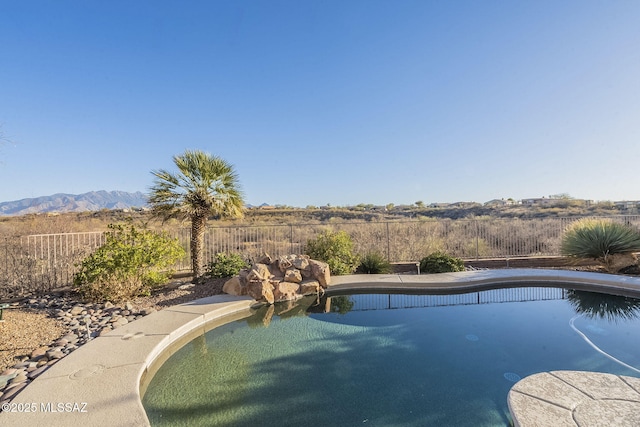 view of pool featuring a fenced backyard, a mountain view, and a fenced in pool