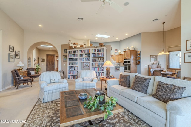 living room with arched walkways, recessed lighting, a ceiling fan, and light colored carpet