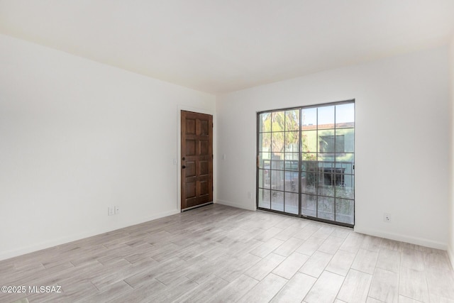 empty room with light wood finished floors and baseboards