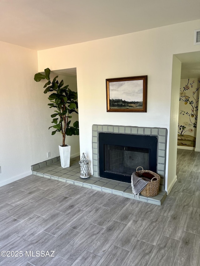 details with wood finished floors, a tile fireplace, and visible vents