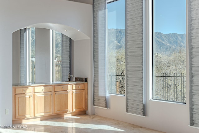 bar featuring arched walkways, a sink, and a mountain view