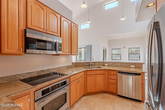 kitchen featuring light stone counters, stainless steel appliances, high vaulted ceiling, pendant lighting, and a sink