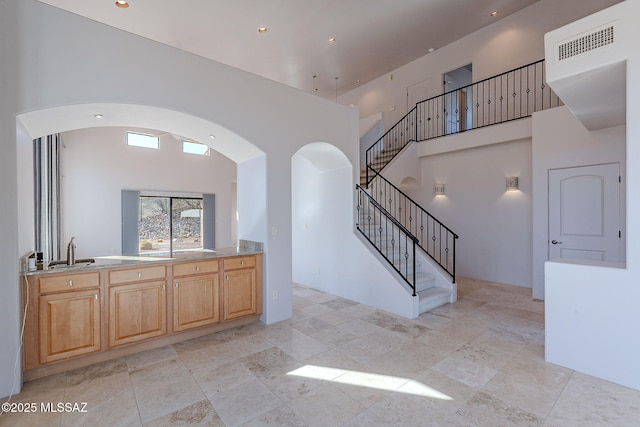 interior space featuring light countertops, a high ceiling, a sink, and visible vents