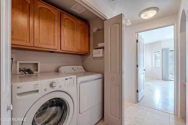 washroom with cabinet space, light tile patterned floors, visible vents, and independent washer and dryer