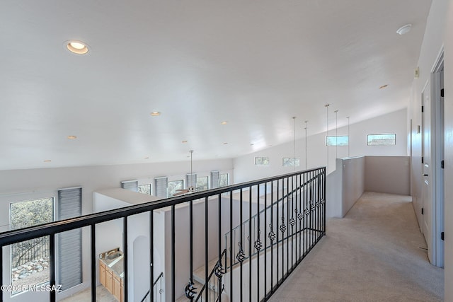 hall featuring light carpet, plenty of natural light, vaulted ceiling, and recessed lighting