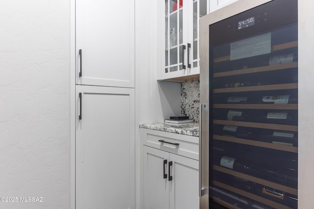 interior space featuring beverage cooler, a textured wall, and decorative backsplash