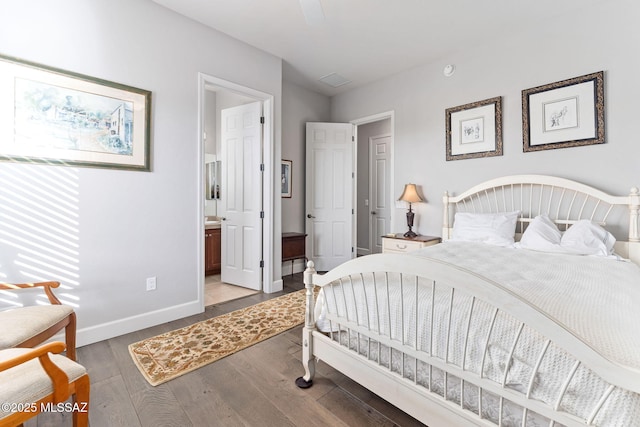 bedroom featuring wood finished floors, connected bathroom, and baseboards