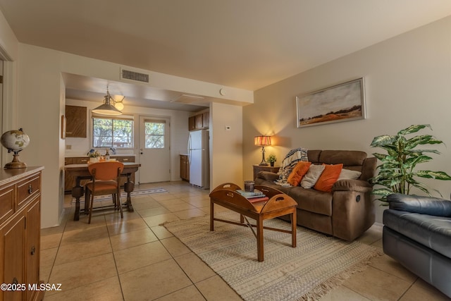 living room featuring light tile patterned floors and visible vents