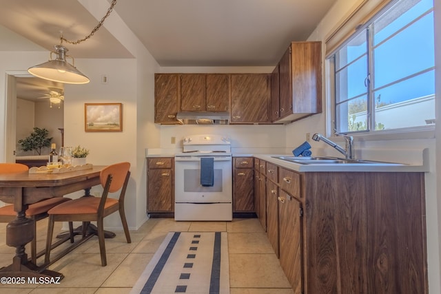 kitchen with hanging light fixtures, light countertops, white electric range, under cabinet range hood, and a sink