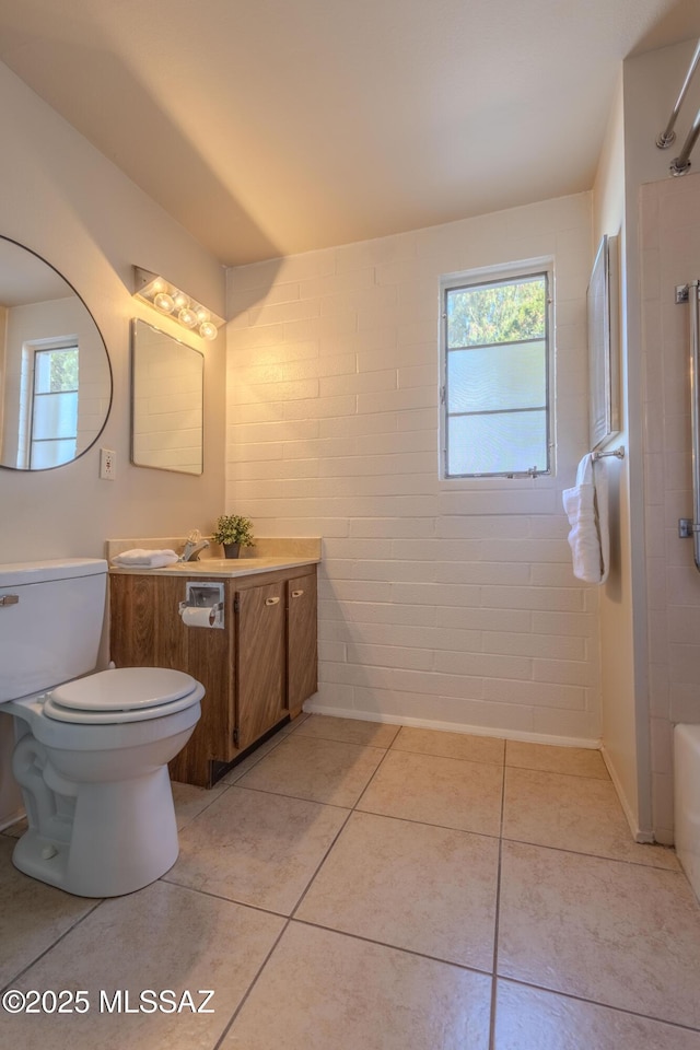 full bath featuring tile patterned flooring, a healthy amount of sunlight, vanity, and toilet