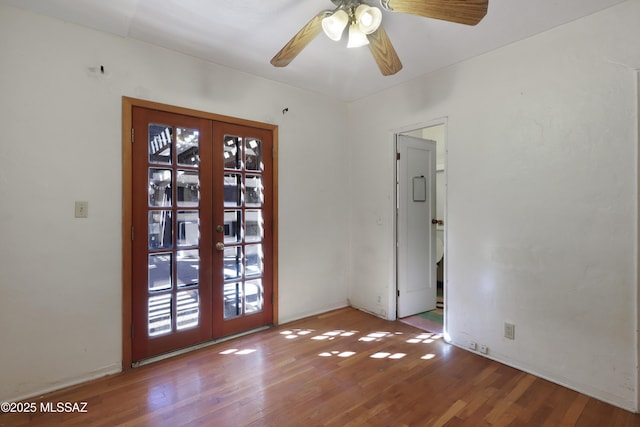 spare room featuring light wood finished floors, a ceiling fan, and french doors