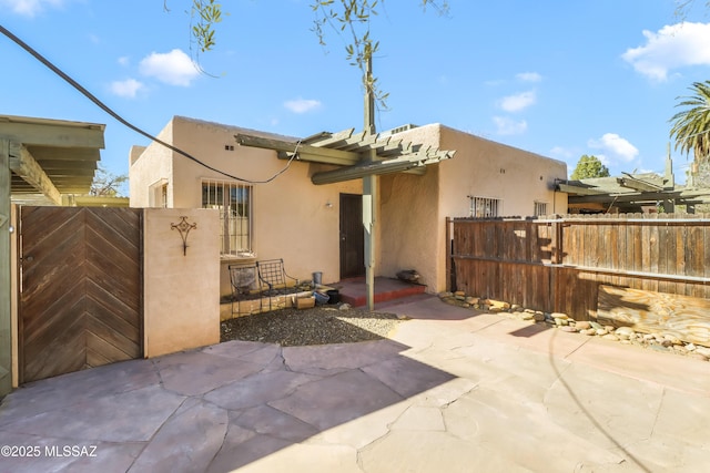 back of property featuring a patio area, fence, and stucco siding