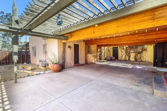 view of patio featuring an attached carport, fence, and a pergola