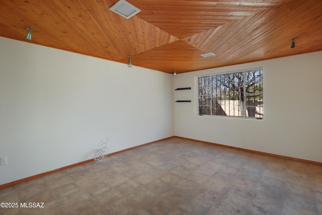 empty room featuring wood ceiling and baseboards