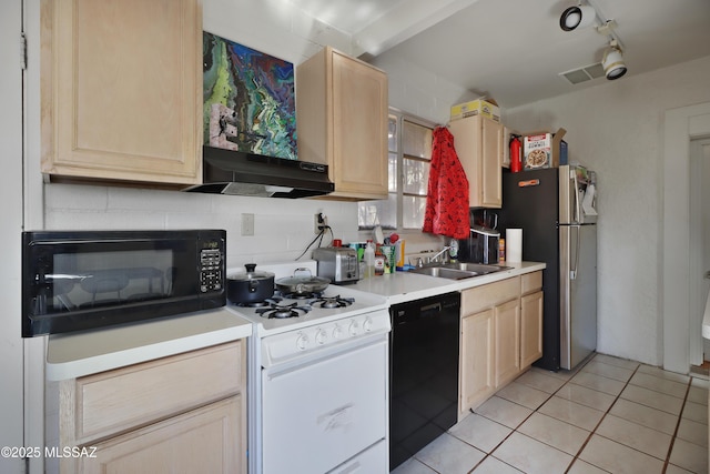 kitchen with under cabinet range hood, light countertops, light brown cabinetry, black appliances, and a sink