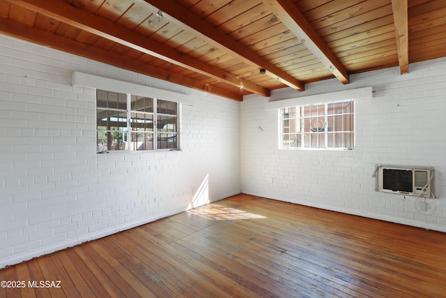 unfurnished room with wooden ceiling, brick wall, hardwood / wood-style floors, and beamed ceiling