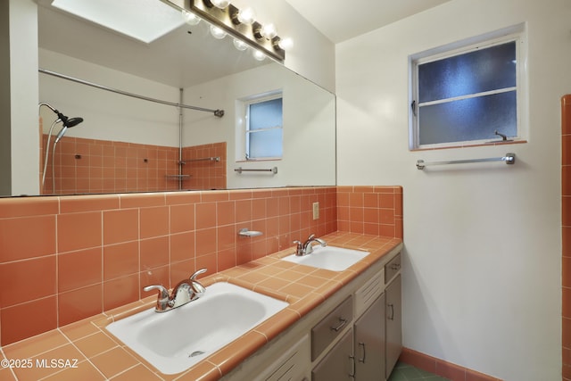 full bathroom with tasteful backsplash, a sink, and double vanity